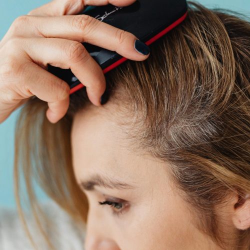 A woman brushing her hair showing hair texture and care.